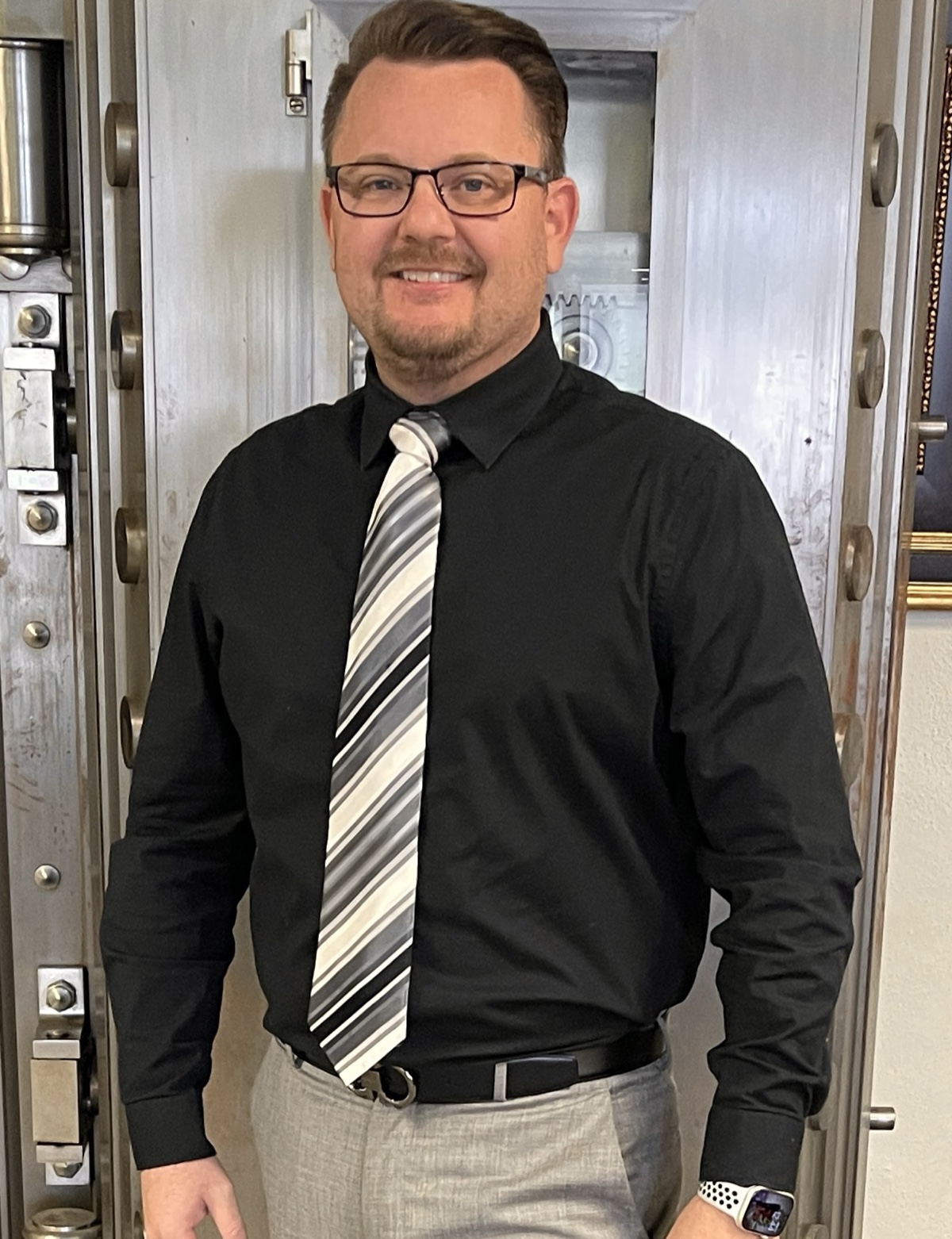 Derek Hazelwood standing in front of an open bank vault door