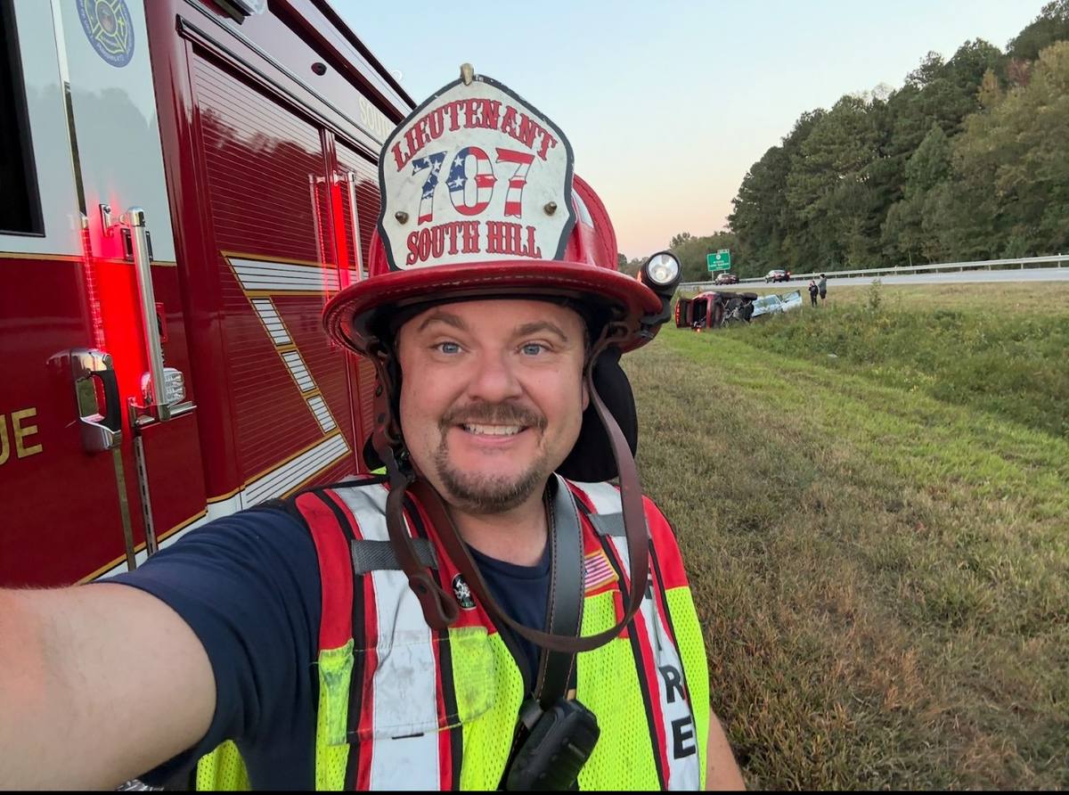 Lieutenant Derek Hazelwood in helmet and traffic vest at a roadside incident at dusk