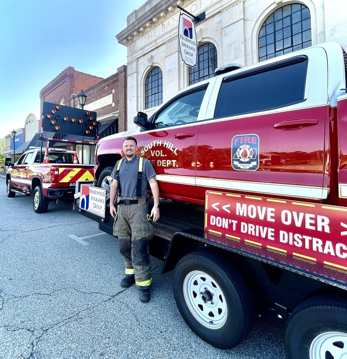 Derek Hazelwood beside the wrecked South Hill command truck on its trailer, Move Over Law display, downtown South Hill