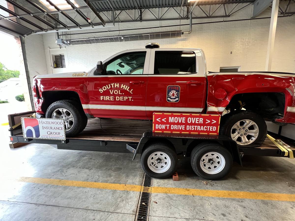 The wrecked South Hill command truck loaded on its display trailer inside the station bay