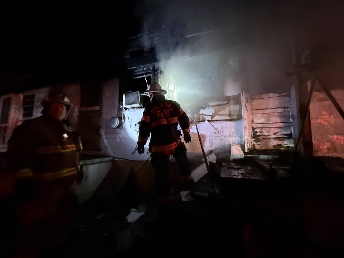 Two firefighters overhauling a fire damaged room, South Hill Volunteer Fire Department