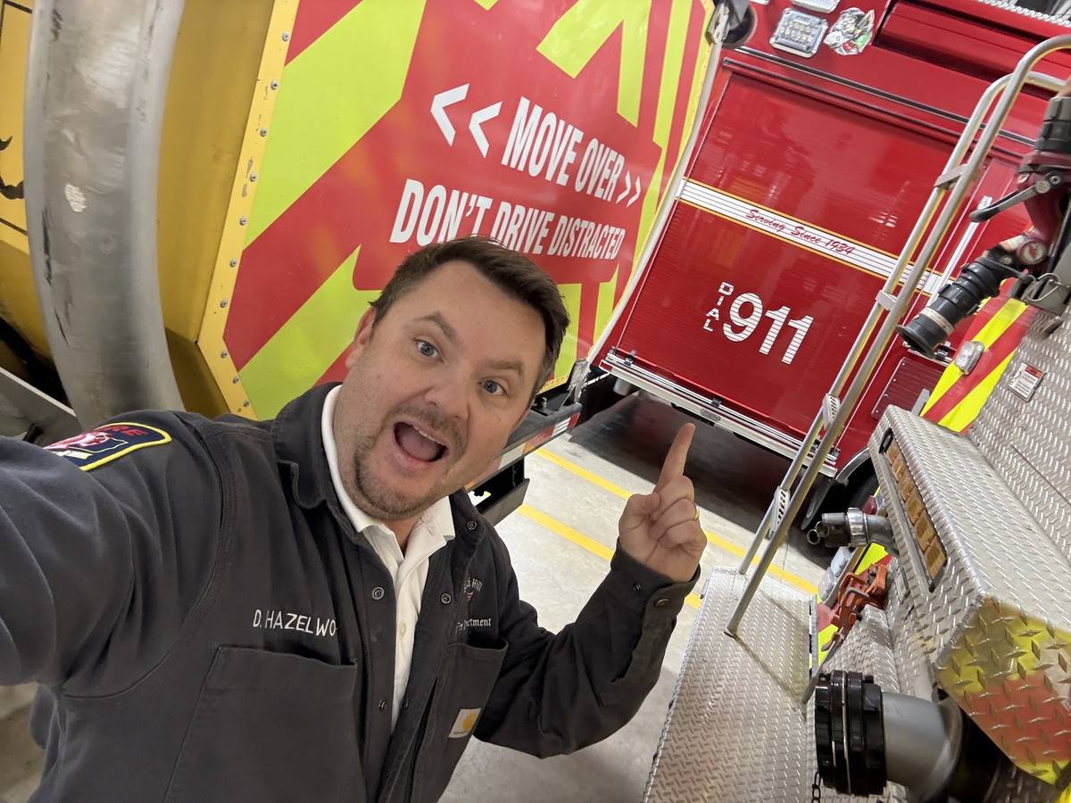 Derek Hazelwood pointing out the Move Over Law message on the wrecked command truck display