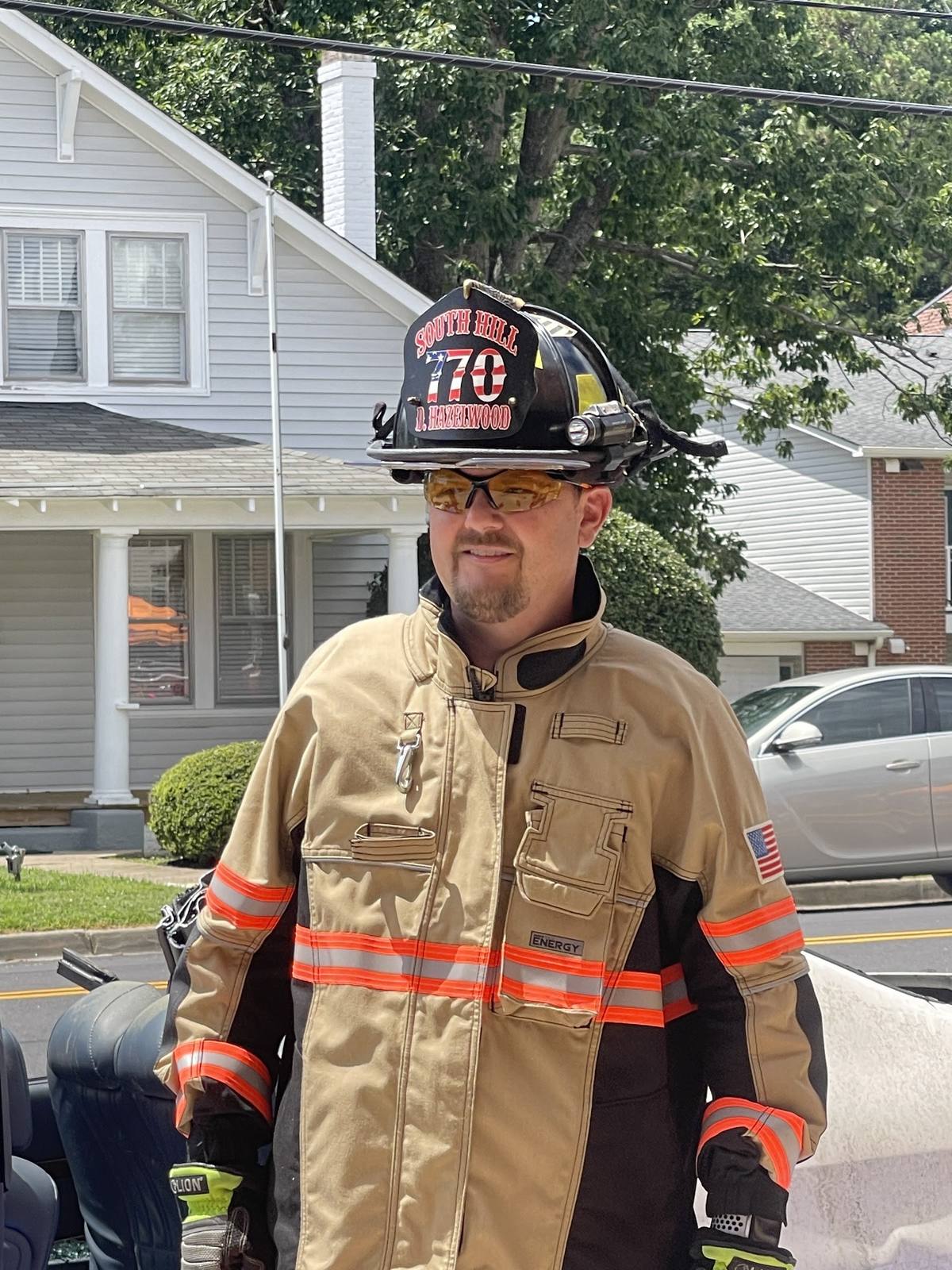 Firefighter in tan turnout gear on a residential street, South Hill Volunteer Fire Department