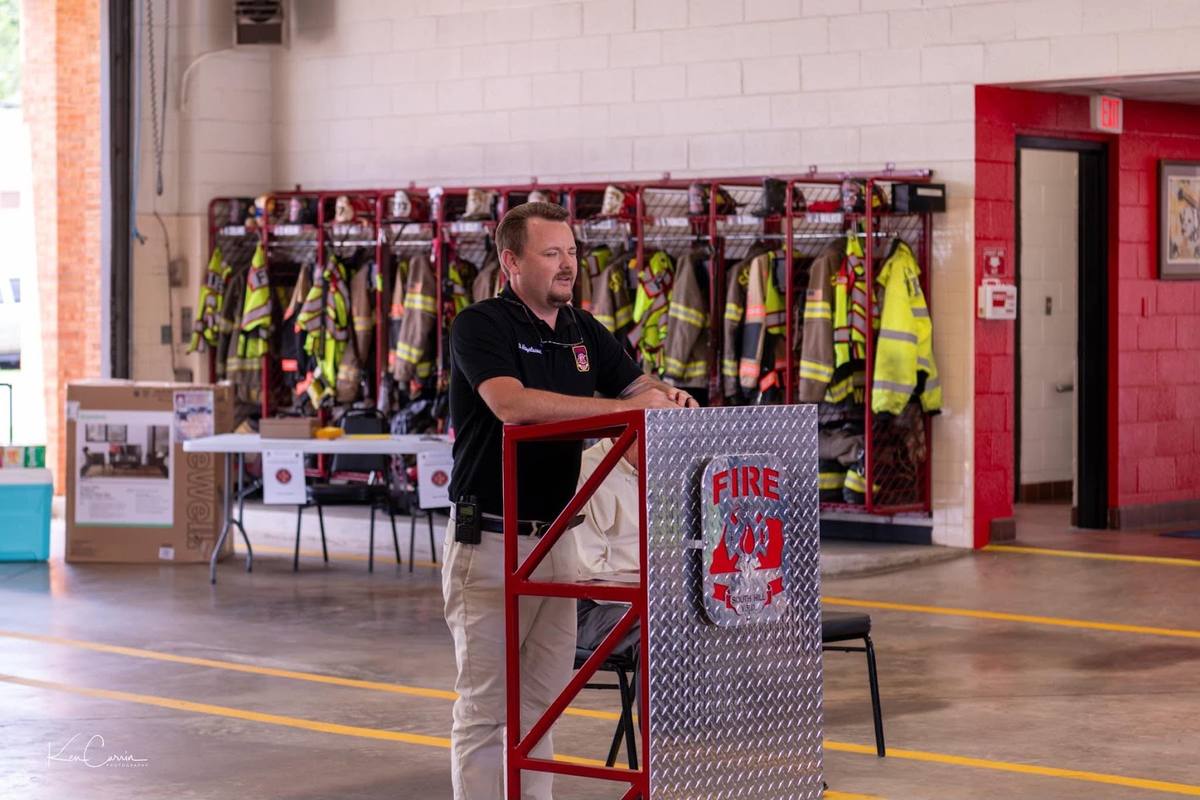 Derek Hazelwood speaking at the podium in the South Hill station bay
