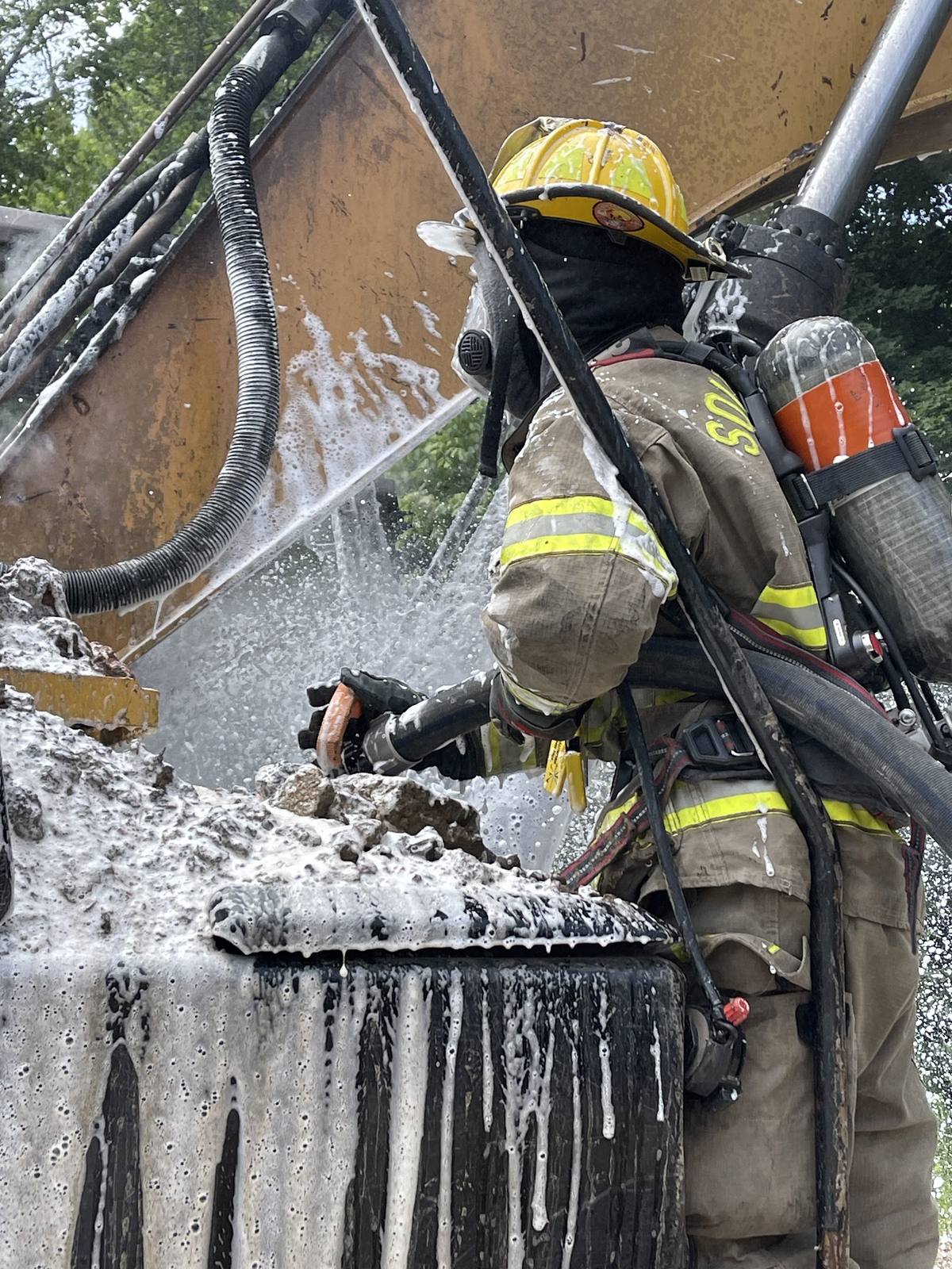 Firefighter extinguishing a container fire, South Hill Volunteer Fire Department